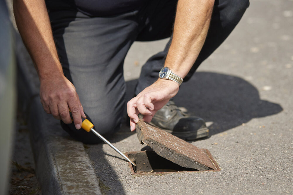 Engineer opening an inspection cover